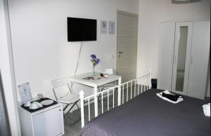 a room with a bed and a television on the wall at Del Toscano Home in Catania