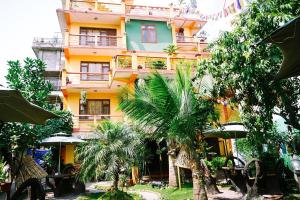 a building with palm trees in front of it at Elbrus Home in Kathmandu