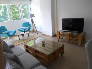 ein Wohnzimmer mit einem TV und einem Couchtisch in der Unterkunft Playa levante vistas al mar in Benidorm