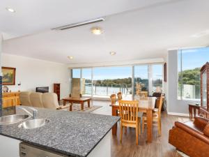 a kitchen and living room with a table and chairs at Regatta 13 in Forster