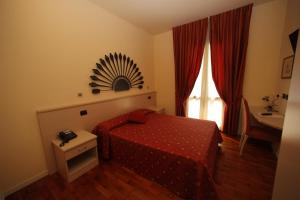 a bedroom with a bed and a table and a window at Hotel Fioroni in Bellagio