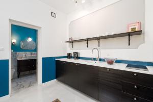 una cocina con armarios marrones y una pared azul y blanca en Piękny Butikowy Apartament Stary Rynek Poznań, en Poznan 27 fotos más