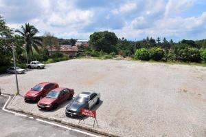 un grupo de tres coches estacionados en un estacionamiento en Hotel Agro en Raub