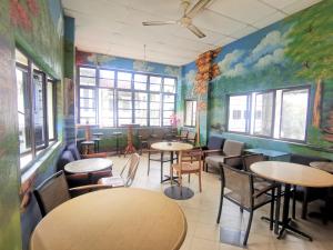 a restaurant with tables and chairs and a mural at Star Lodge in George Town