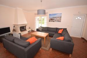 a living room with two couches and a table at Casa Luna in Praia da Arrifana