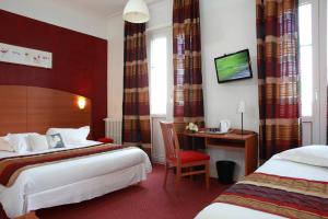 a hotel room with two beds and a desk at Alerion Centre Gare in Metz
