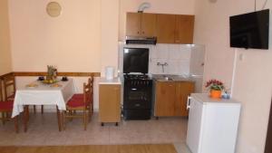 eine Küche mit einem Tisch und eine Küche mit einem Kühlschrank in der Unterkunft Apartmani A.Teskera in Trogir