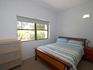 1 dormitorio con cama y ventana en Sandcastle 7 with WiFi, en Tuncurry
