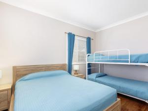 a bedroom with two bunk beds and a window at Sandy Toes in Forster