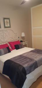 1 dormitorio con 1 cama grande con manta roja y negra en Primavera gelijkvloers appartement met ruim terras en wifi, en Costa del Silencio