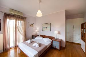ein Schlafzimmer mit einem großen Bett mit weißer Bettwäsche und Kissen in der Unterkunft Violet Luxury Villa in Lefkada Town