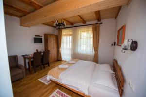 a bedroom with a large bed and a dining room at Pensiunea Agroturistica Raluca in Vadu Izei
