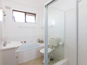 a bathroom with a tub and a toilet and a sink at Seabreeze 4 Opposite Bowling Club in Tuncurry