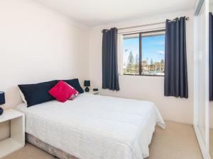 a bedroom with a white bed and a window at Seabreeze 4 opposite the bowling club Tuncurry in Tuncurry