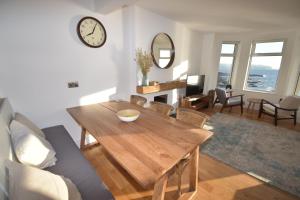 uma sala de estar com uma mesa de madeira e um relógio na parede em The Promenade, Portstewart em Portstewart