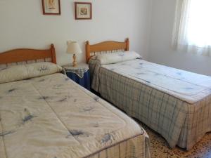 1 dormitorio con 2 camas y mesa con lámpara en Samoa Basic, en Salou
