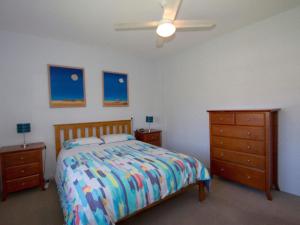Un dormitorio con una cama y una cómoda. en Sandcastle 7 with WiFi, en Tuncurry