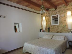 a bedroom with a bed and a stone wall at Agroturisme Es Picot in Son Macia