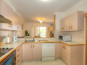 a kitchen with white cabinets and a sink at St James 6 in Tuncurry