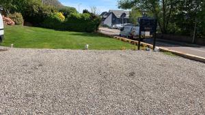a gravel driveway with a sign and a street at Cromarty View Guest House in Dingwall