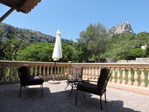 un patio con 2 sillas, una mesa y una sombrilla en Agroturisme Es Picot en Son Macià