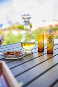 a bottle of oil and two glasses on a table at Tranquility House in Livadia