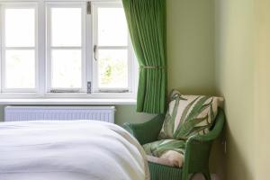 a bedroom with a bed and a chair next to a window at The Hayloft, Wall End Farm in Leominster