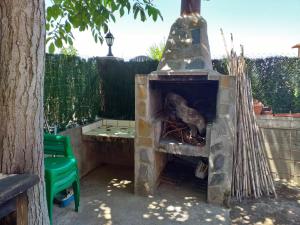 una chimenea de piedra en un patio con una silla verde en CASA el NOGAL, en Salas Bajas