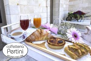 a table with a tray of pastries and coffee and drinks at Castello Salentino B&B Melendugno in Melendugno