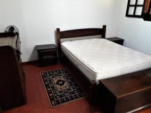 a bedroom with a bed and two tables and a rug at Recanto do Ribeirão in Pindamonhangaba +46 photos