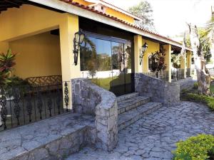 a house with a stone porch and a glass door at Recanto do Ribeirão in Pindamonhangaba