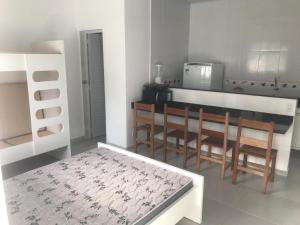 a kitchen with a table and chairs and a microwave at Kitnet in Ubatuba
