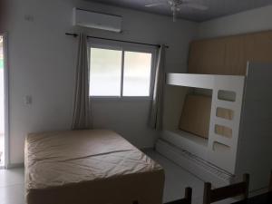 a bedroom with a bunk bed and a window at Kitnet in Ubatuba