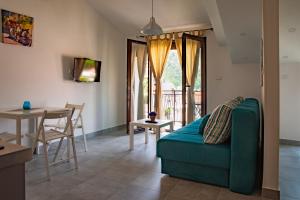 sala de estar con sofá verde y mesa en Rooms & Apartments Vukasović, en Kotor