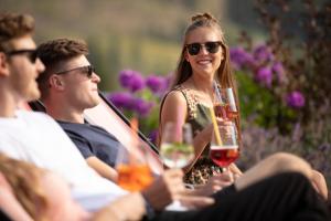 a group of people sitting around a table with glasses of wine at Berghotel Der Königsleitner - Adults only in Königsleiten