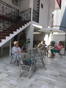 a group of people sitting in chairs on a patio at Magnolia Guest House in K'obulet'i