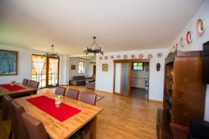 a dining room and living room with a table and chairs at Pensiunea Agroturistica Raluca in Vadu Izei