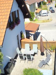 um pátio com cadeiras, uma mesa e um telhado em Ferienwohnung Oswald em Isny im Allgäu