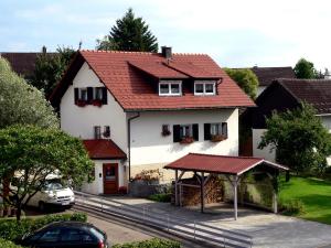 uma casa branca com um telhado vermelho em Ferienwohnung Oswald em Isny im Allgäu