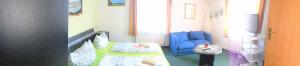 ein Wohnzimmer mit einem blauen Sofa und ein Wohnzimmer mit einem Sofa in der Unterkunft Erbgericht in Bad Schandau