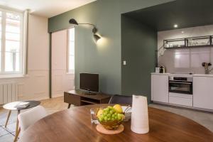 a living room with a table with a bowl of fruit at L'Opéra - Bel appartement au pied du Capitole in Toulouse