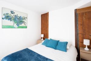 a bedroom with a white bed with blue pillows at L'Esquisse by Cocoonr in Nantes
