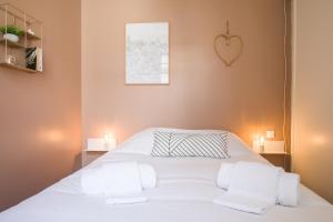 a bedroom with a white bed with a heart on the wall at L'Opéra - Bel appartement au pied du Capitole in Toulouse +4 photos