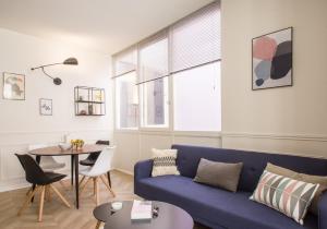 a living room with a blue couch and a table at L'Opéra - Bel appartement au pied du Capitole in Toulouse