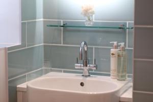 a bathroom with a sink and a soap dispenser at Hedges House in Buckingham