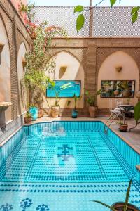 een zwembad in een gebouw met een zwembad bij Amani Hotel Suites & Spa in Marrakesh