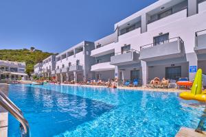 a large swimming pool with a large swimming pool behind it at Sunrise Village Hotel - All Inclusive in Platanias