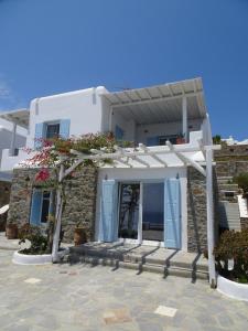 a white house with blue doors and a porch at enJOY the sea and relax in Mikonos