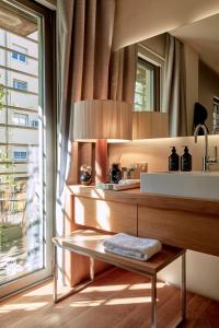 a bathroom with a table and a sink and a mirror at Sir Victor Hotel, part of Sircle Collection in Barcelona