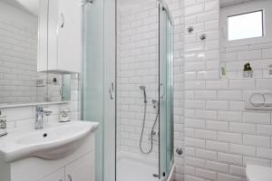 a white bathroom with a sink and a shower at Apartment Sersic in Baška